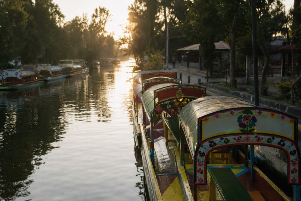 A quiet weekday dock with empty canopied boats moored in a neat line and no queue in sight